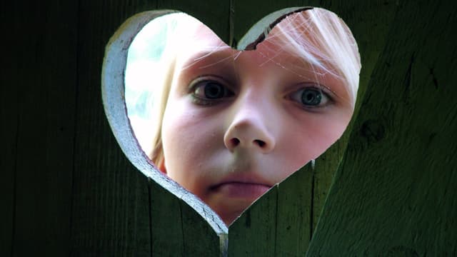 Huussin ikkunaluukussa tyttö