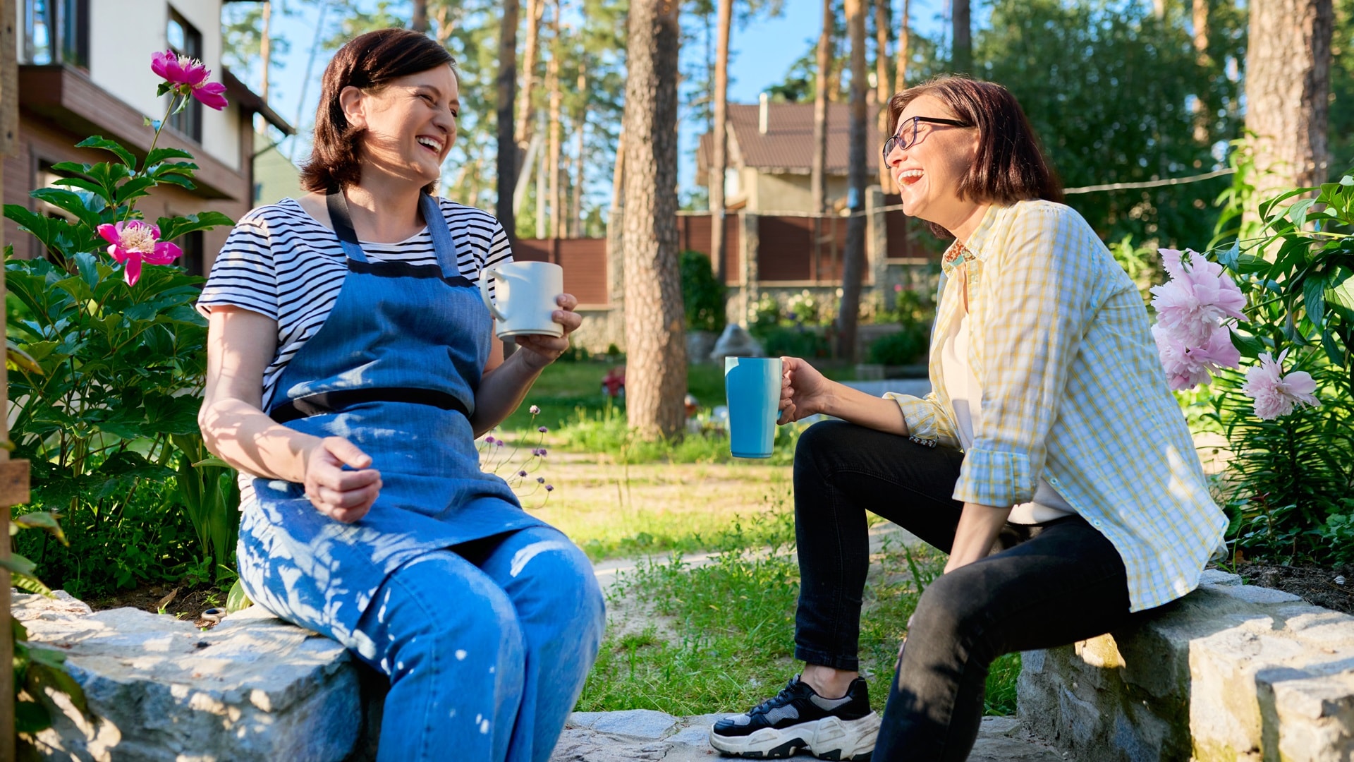 two-middle-aged-women-sitting-outdoors-together-in